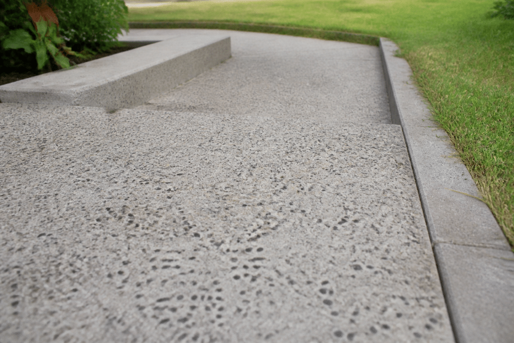 Surface de béton gris avec granulats visibles et texture drainante