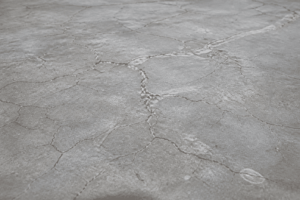 Ciment gris avec fissures visibles sur surface large
