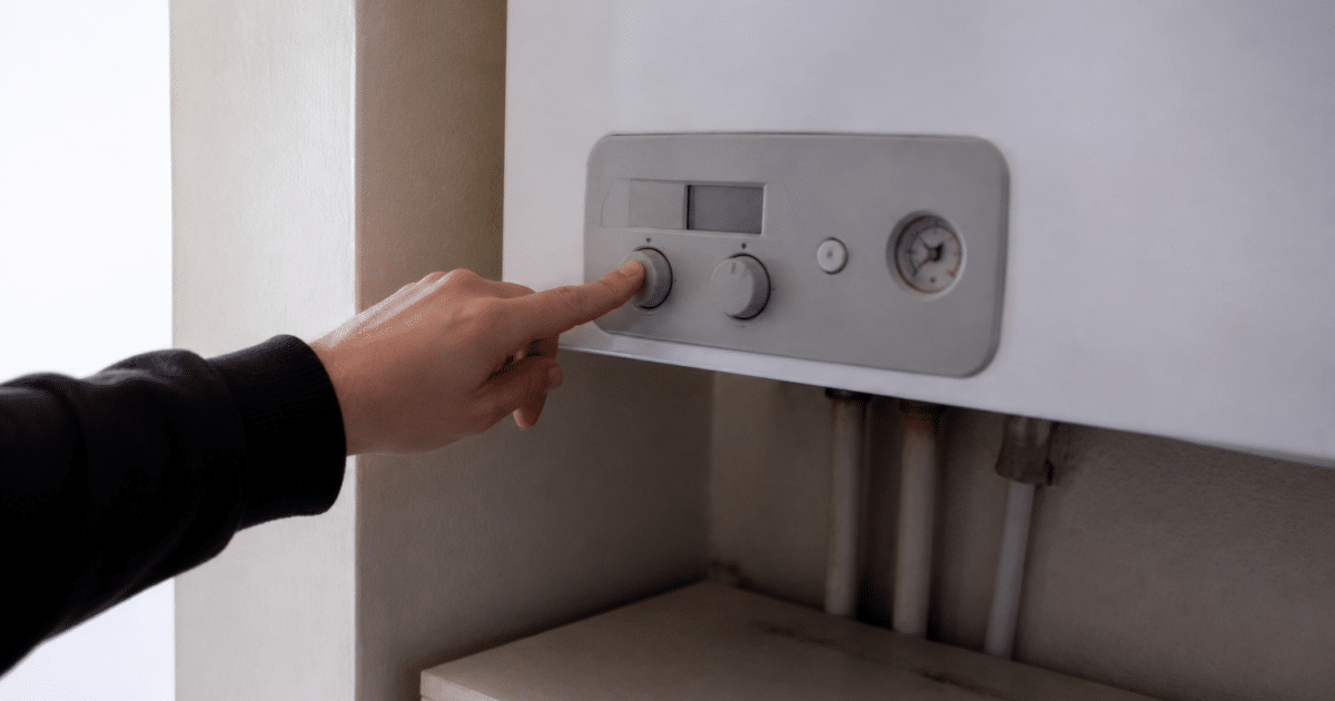 Main appuyant sur bouton arret chaudiere gaz murale