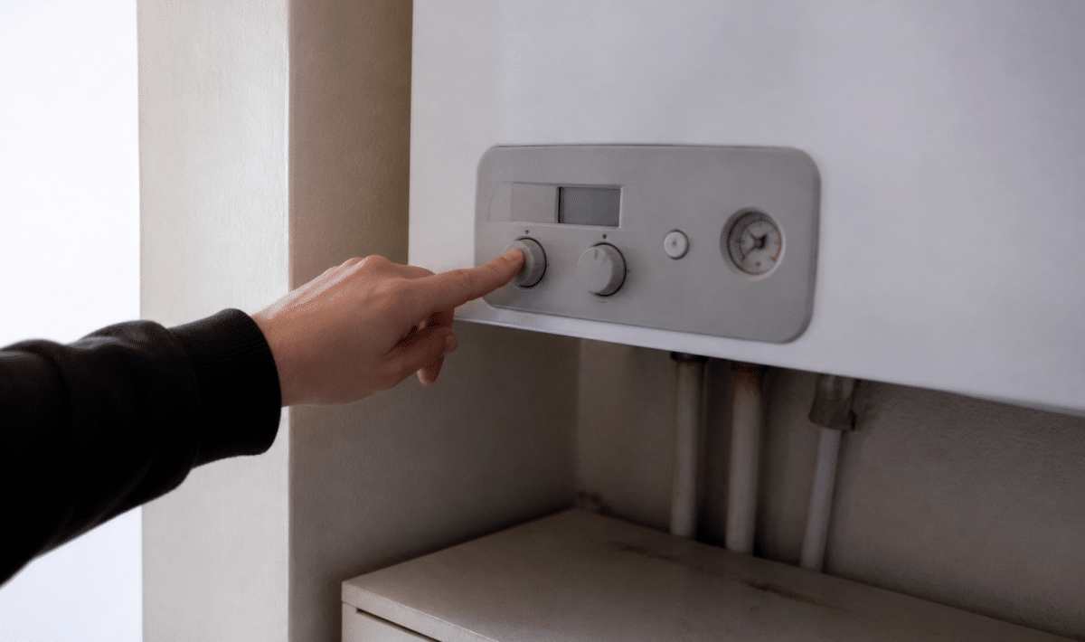 Main appuyant sur bouton arret chaudiere gaz murale