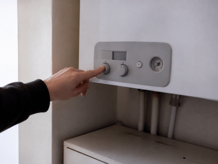 Main appuyant sur bouton arret chaudiere gaz murale