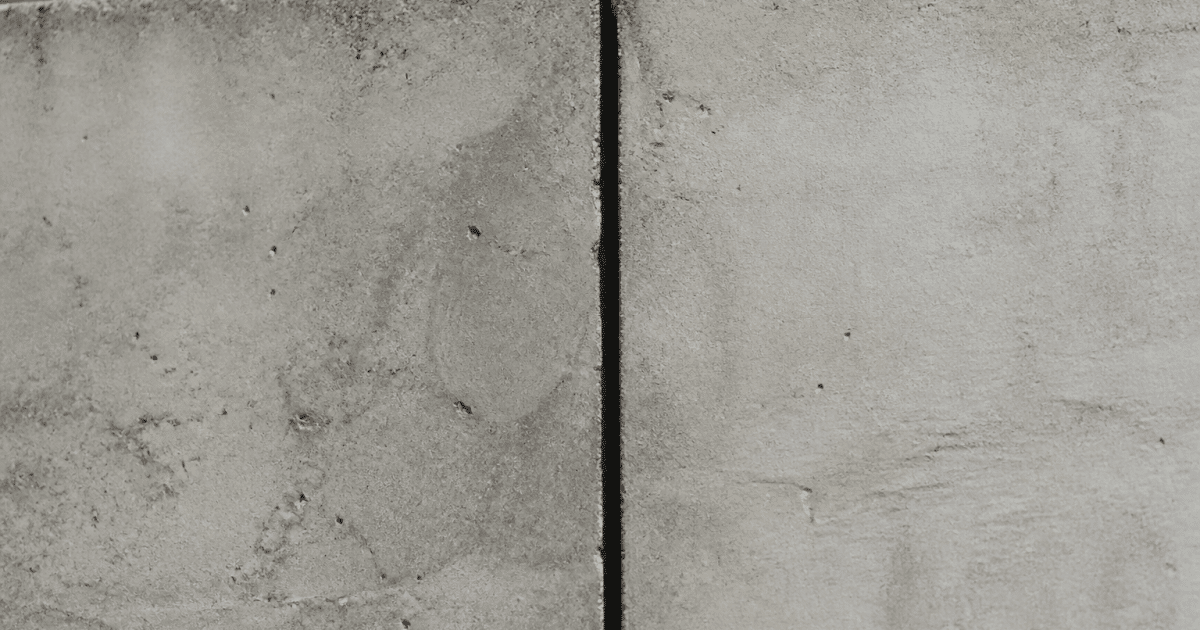 Fissure verticale separant deux sections beton gris jointees