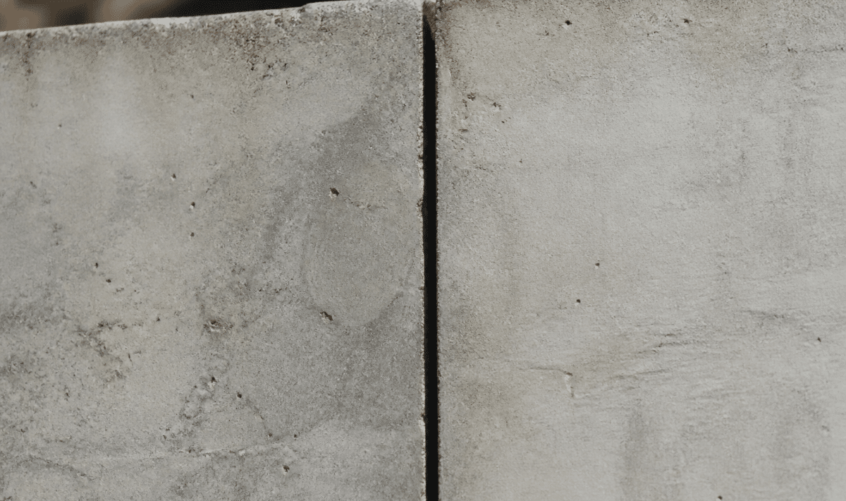 Fissure verticale separant deux sections beton gris jointees