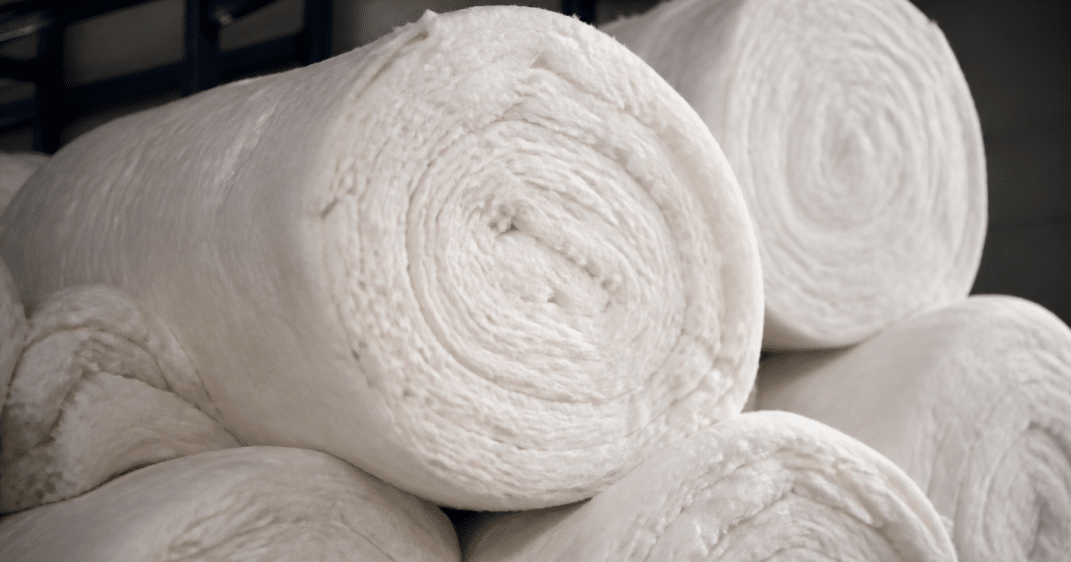 Rouleaux isolants empiles montrant materiaux fibreux blancs epais