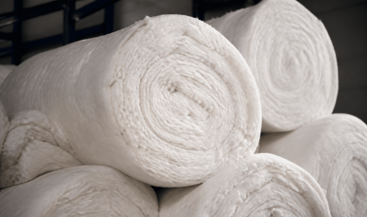 Rouleaux isolants empiles montrant materiaux fibreux blancs epais
