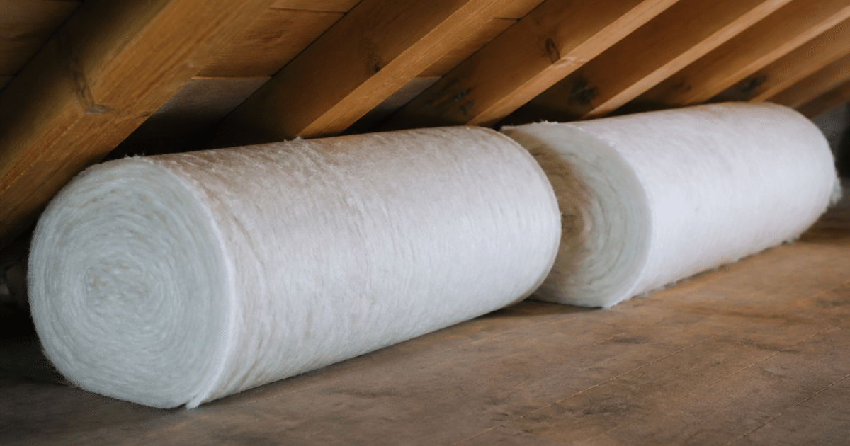 Rouleaux isolants blancs poses horizontalement sous charpente bois