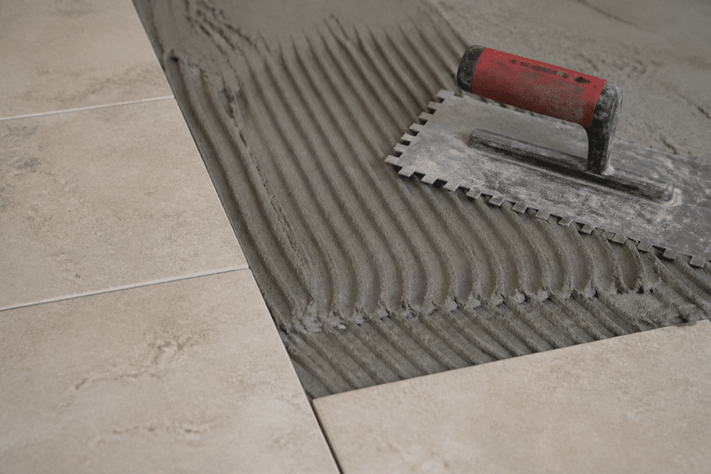 Mortier gris applique au peigne sur carrelage beige