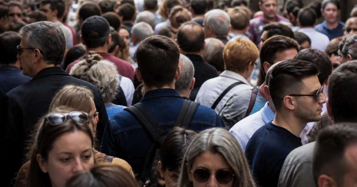 Foule de personnes debout serrees dans une rue urbaine