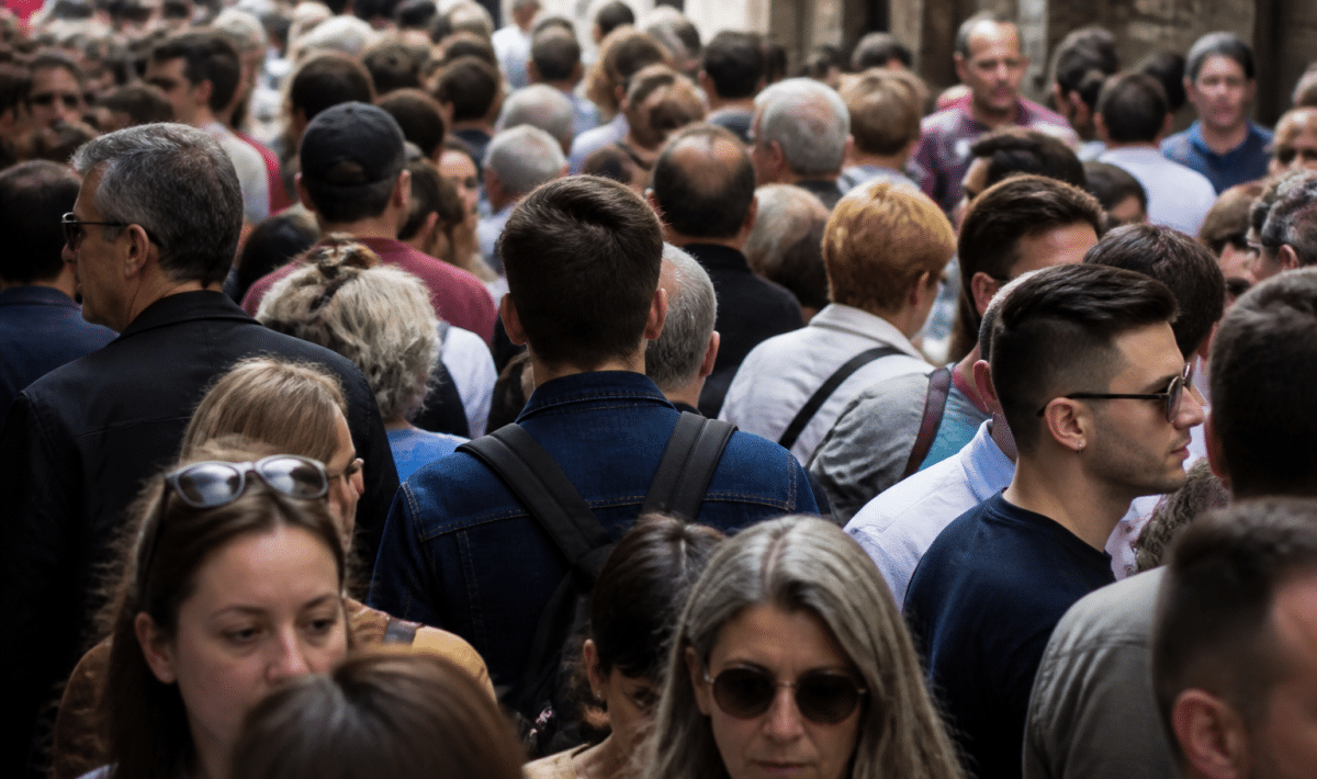 Foule de personnes debout serrees dans une rue urbaine