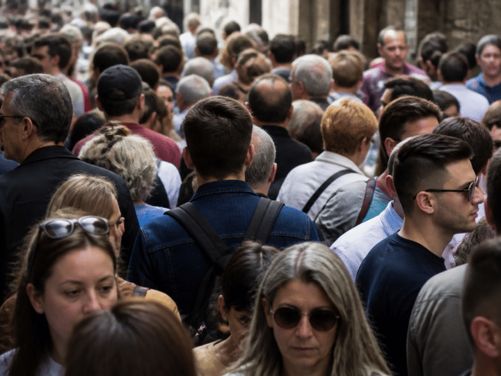 Foule de personnes debout serrees dans une rue urbaine