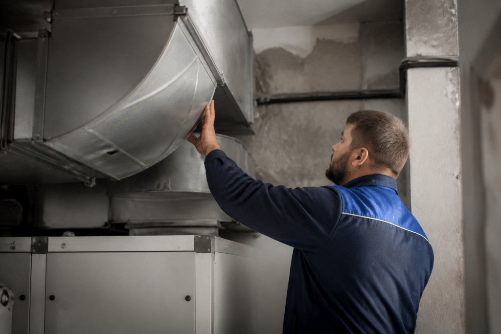 Technicien inspectant conduit ventilation collective immeuble
