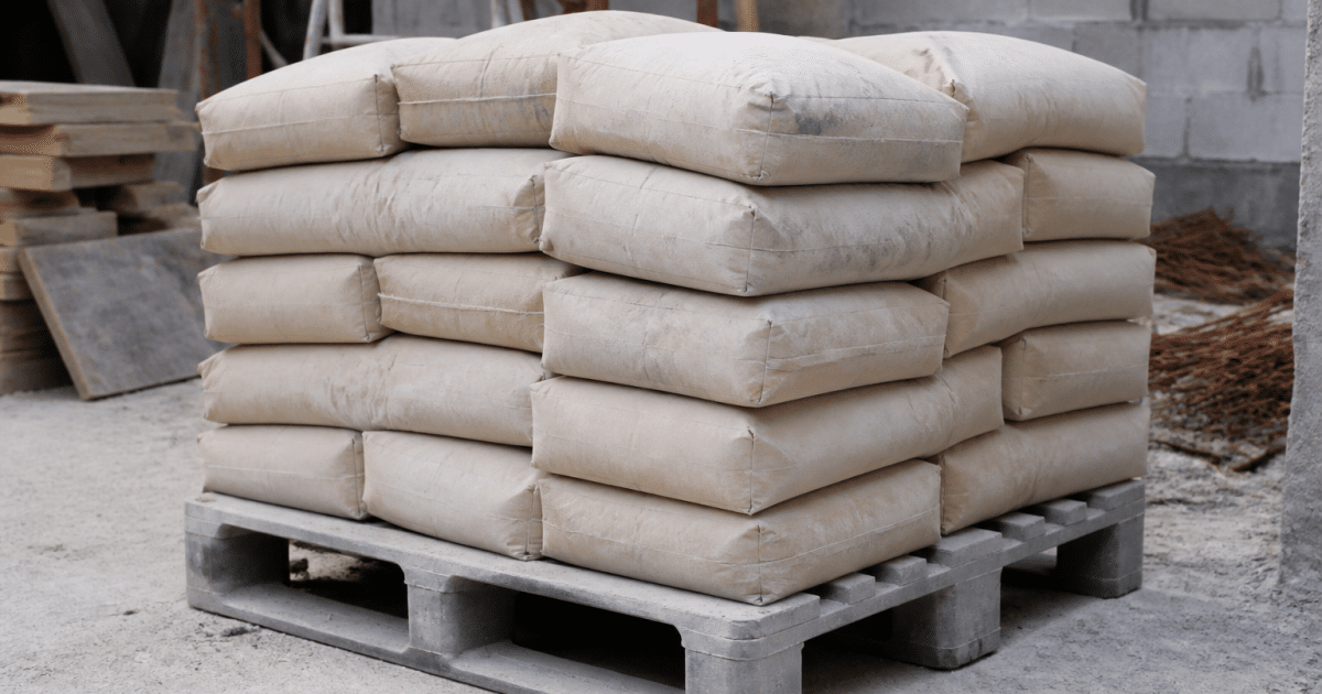 Sacs de ciment empiles sur palette grise chantier