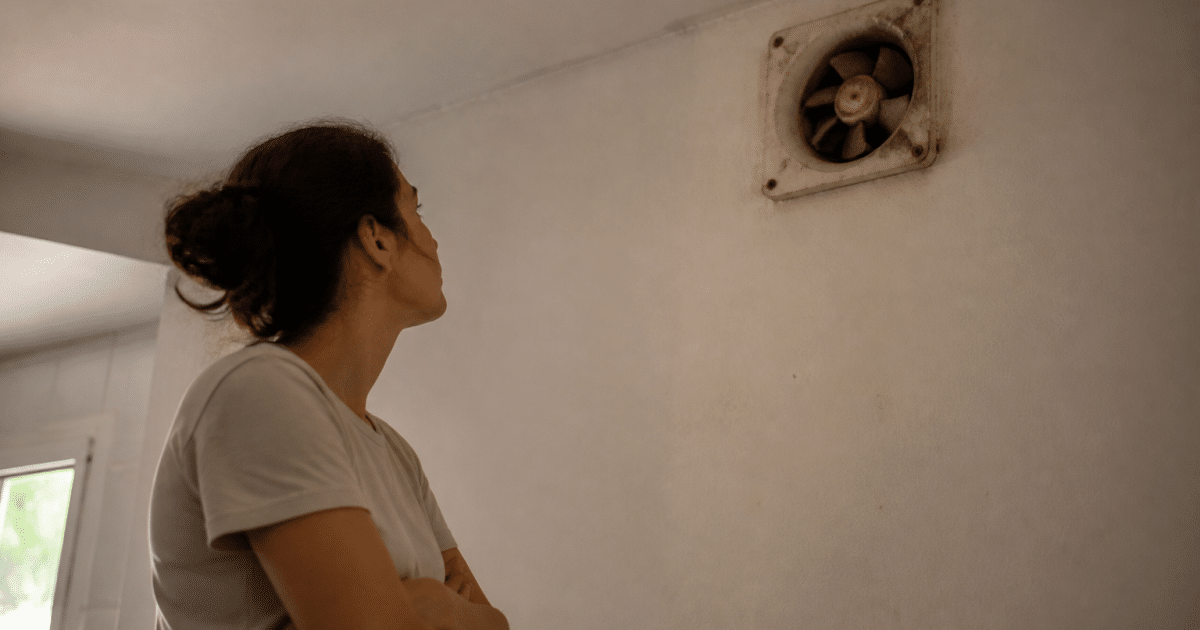personne regardant ventilation murale defaillante bras croises attente