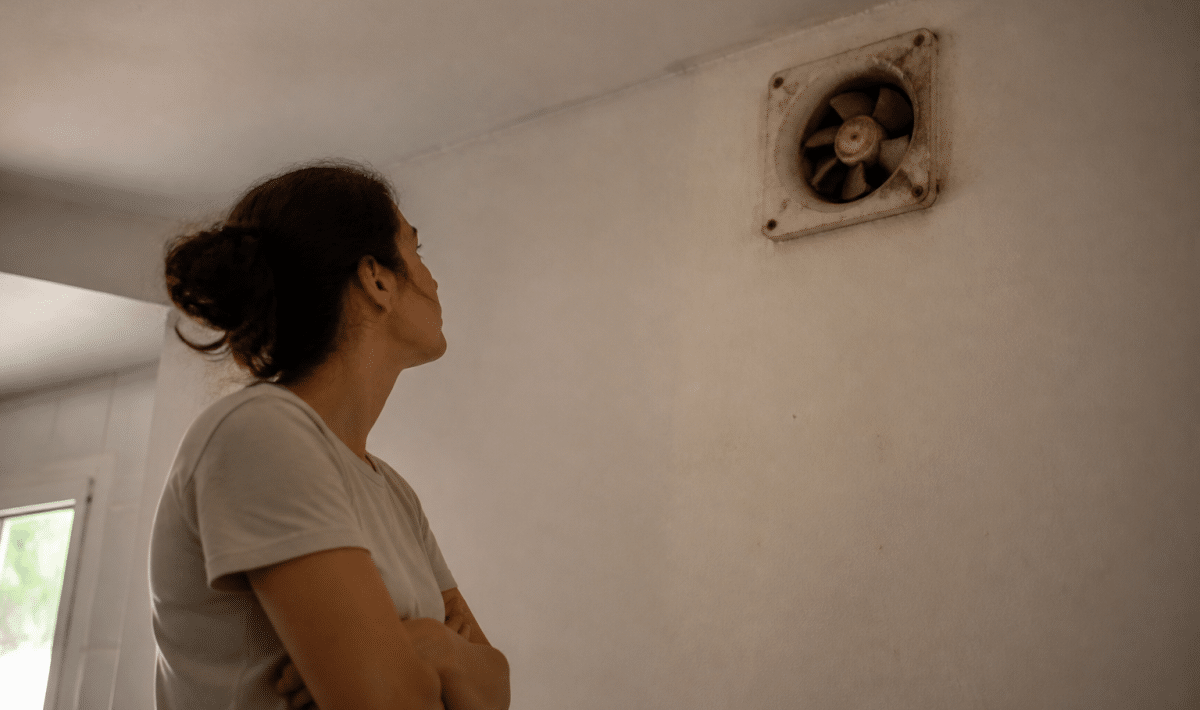 personne regardant ventilation murale defaillante bras croises attente