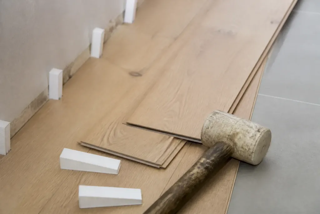 Lames de bois clair, cales blanches et maillet